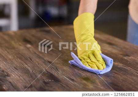 Effectively Cleaning A Table Surface With A Sponge For A Neat And Tidy Appearance Effectively Cleaning A Table Surface With A Sponge For A Neat And Tidy Appearance 125662851