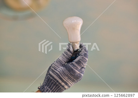 Replacing a light bulb in a home needs specific tools and techniques for safety and efficiency 125662897