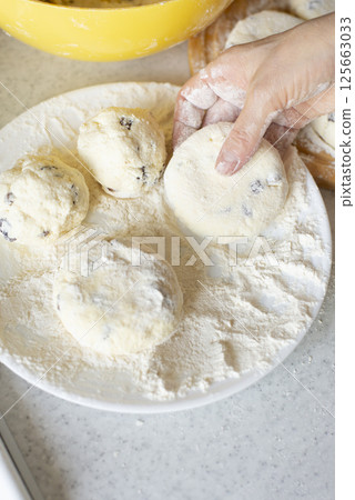 Caucasian hands making cottage cheese pancakes with raisins Caucasian hands making cottage cheese pancakes with raisins 125663033