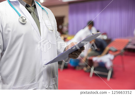 Doctor in gown uniform with stethoscope standing and holding chart in the quarantine room for the corona virus infected patients. 125663352