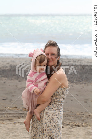 Carefree mother embracing her daughter baby girl. Young woman and child one year old Carefree mother embracing her daughter baby girl. Young woman and child one year old 125663403