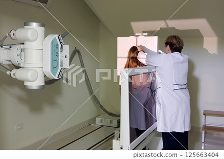 Doctor preparing girl for x-ray in hospital Doctor preparing girl for x-ray in hospital 125663404