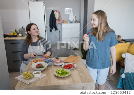 Portrait of enjoy happy family mother with daughter cooking food with healthy fresh vegetable Portrait of enjoy happy family mother with daughter cooking food with healthy fresh vegetable 125663412