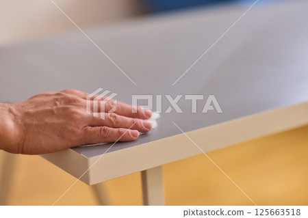 Performing the task of cleaning surfaces with a cloth for a fresh and polished look Performing the task of cleaning surfaces with a cloth for a fresh and polished look 125663518