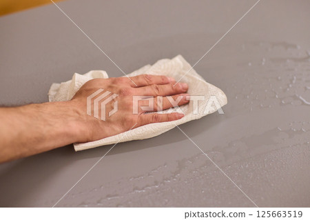 Performing the task of cleaning surfaces with a cloth for a fresh and polished look Performing the task of cleaning surfaces with a cloth for a fresh and polished look 125663519