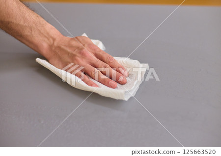Performing the task of cleaning surfaces with a cloth for a fresh and polished look 125663520