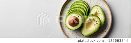 A beautiful arrangement of fresh avocado slices on a plate showcasing healthy eating. 125663844