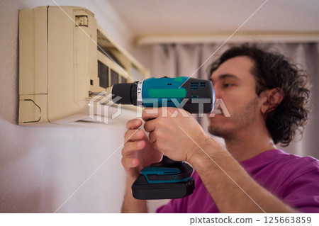 Technician Expertly Installing a New Air Conditioning Unit in a Contemporary Modern Home Technician Expertly Installing a New Air Conditioning Unit in a Contemporary Modern Home 125663859