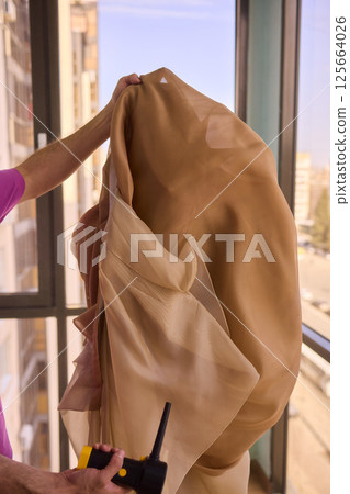 A Young Man Holding a Soft Blanket by the Window, Highlighting His Carefree Spirit 125664026