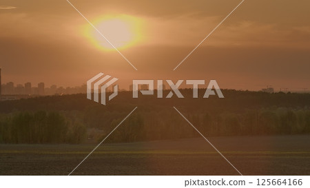 Experience the breathtaking beauty of a majestic sunset setting over an urban landscape 125664166