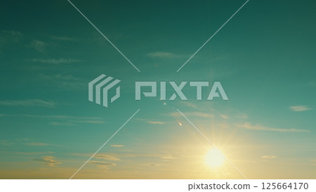 A radiant sunrise casts warm glow on the horizon, creating an aweinspiring atmosphere A radiant sunrise casts warm glow on the horizon, creating an aweinspiring atmosphere 125664170