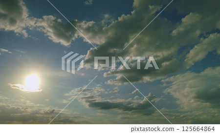 A Majestic Cloudy Sky Enhanced by Soft Sunlight Brightly Shining Through the Clouds 125664864