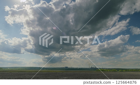 Dynamic and Captivating Cloudy Skies Over a Lush and Vibrant Landscape of Nature 125664876