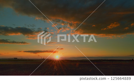 Witness a serene sunset with warm colors and clouds, inspiring peace and relaxation at dusk 125664889