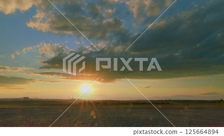 A Breathtaking Stunning Sunset Over a Serene Landscape Surrounded by Colorful Beautiful Skies 125664894
