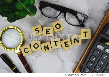 SEO Content with wooden blocks alphabet letters and Magnifying glass and calculator on marble background 125664903