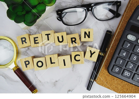 Return Policy with wooden blocks alphabet letters and Magnifying glass and calculator on marble background 125664904
