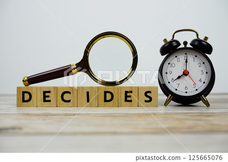 Time to Decides with wooden blocks alphabet letters and Magnifying glass on wooden background 125665076