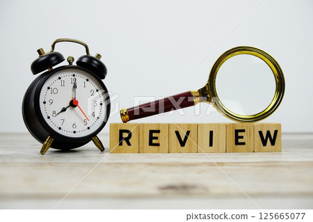 Time to Review with wooden blocks alphabet letters and Magnifying glass on wooden background Time to Review with wooden blocks alphabet letters and Magnifying glass on wooden background 125665077