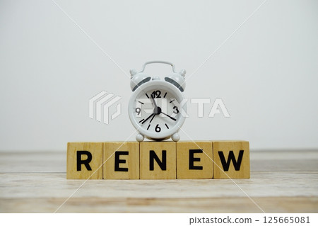 Time to Renew with wooden blocks alphabet letters and alarm clock on wooden background Time to Renew with wooden blocks alphabet letters and alarm clock on wooden background 125665081