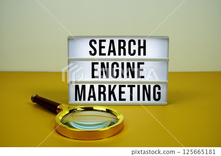 Search Engine Marketing text on LED lightbox with magnifying glass on yellow background Search Engine Marketing text on LED lightbox with magnifying glass on yellow background 125665181