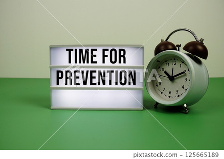 Time for Prevention text on LED lightbox with alarm clock on green background Time for Prevention text on LED lightbox with alarm clock on green background 125665189