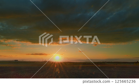 A Stunning Sunrise That Illuminates a Serene Landscape with Dramatic and Colorful Clouds A Stunning Sunrise That Illuminates a Serene Landscape with Dramatic and Colorful Clouds 125665236