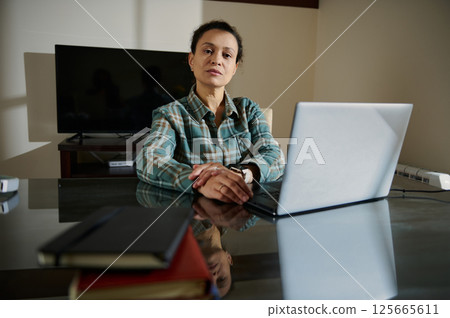 Confident Woman Working Remotely at Home Office with Laptop 125665611