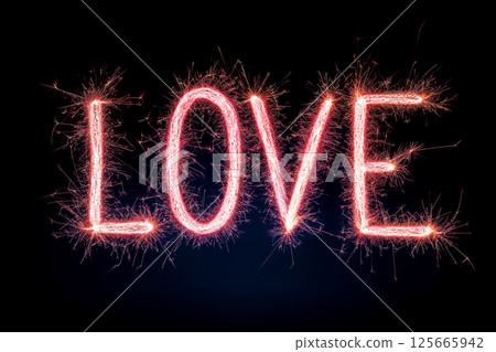 A sparkling representation of the word "Love" illuminated against a dark background through vibrant sparkler effects, symbolizing passion and affection, Valentines Day celebrations. 125665942