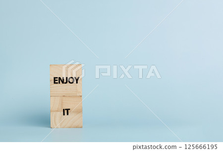 Wooden cubes with inscriptions Enjoy It on a blue background 125666195