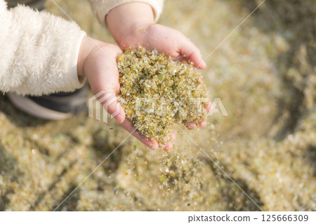 孩子手中收集的閃閃發光的玻璃沙 125666309