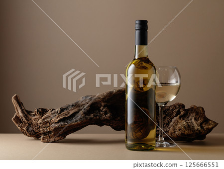 White wine and old snag on a beige background. 125666551