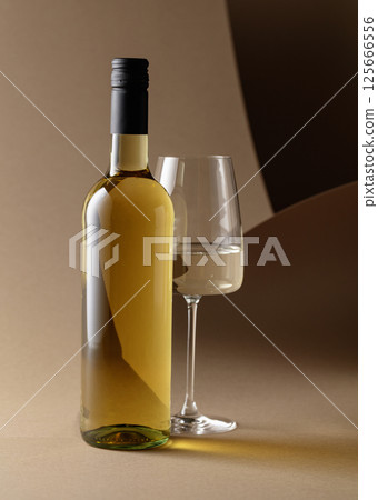 Bottle and glass of white wine. 125666556