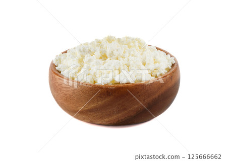 Wooden bowl full of fresh cottage cheese on white background. Wooden bowl full of fresh cottage cheese on white background. 125666662