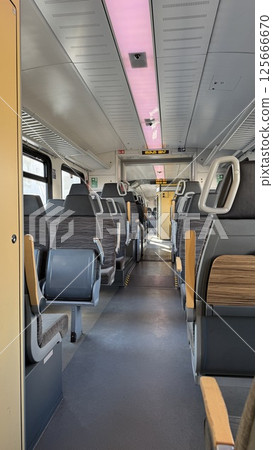 Modern train interior in Germany showcasing empty seats and spacious layout with bright lighting Modern train interior in Germany showcasing empty seats and spacious layout with bright lighting 125666670