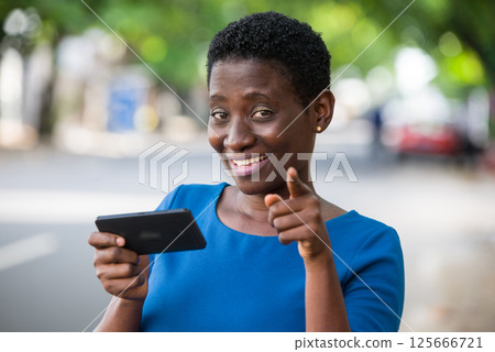 Close-up of young girl with mobile phone, happy. 125666721