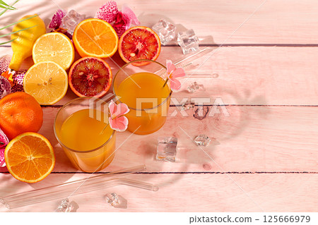 Summer party concept. Sunny tropical banner, background with cocktails and citrus juices. Oranges, lime, grapefruit, lemons and orchid flowers on a bright background. Business card for a bar, cafe. Summer party concept. Sunny tropical banner, background with cocktails and citrus juices. Oranges, lime, grapefruit, lemons and orchid flowers on a bright background. Business card for a bar, cafe. 125666979