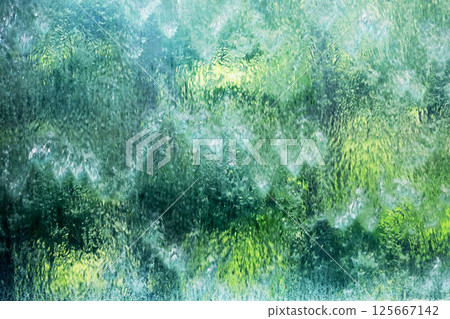 Background material photo of a close-up of an artificial waterfall glowing green 125667142