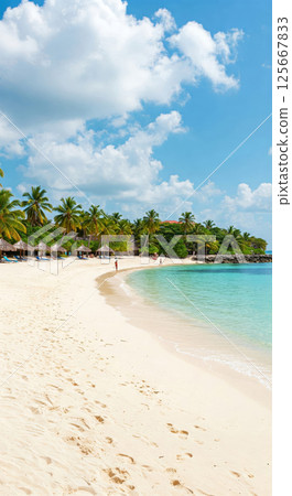Tropical paradise beach with soft white sand, turquoise sea, and lush palm trees under a vibrant blue sky with fluffy clouds 125667833