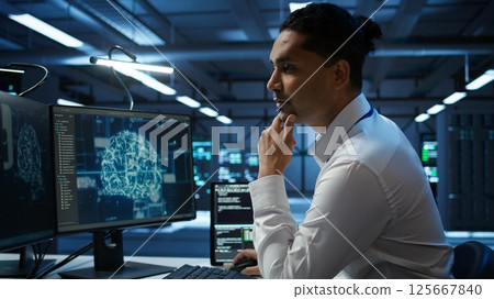 Engineer doing checkup on server hub to optimize it for data processing requirements of AI workloads. Hardworking employee inspects data center used for machine learning, camera B Engineer doing checkup on server hub to optimize it for data processing requirements of AI workloads. Hardworking employee inspects data center used for machine learning, camera B 125667840