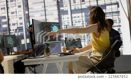 Manager discussing with employees in office, developing artificial intelligence machine learning APIs. Team leader doing brainstorming with workers, training AI predictive models, camera A 125667852