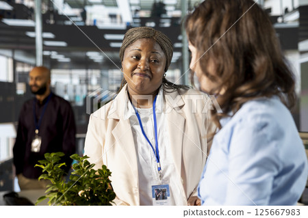 Office worker in trouble feeling distraught about losing her job, african american colleague comforting her after hearing negative news. Woman getting tired, financial difficulties. Office worker in trouble feeling distraught about losing her job, african american colleague comforting her after hearing negative news. Woman getting tired, financial difficulties. 125667983