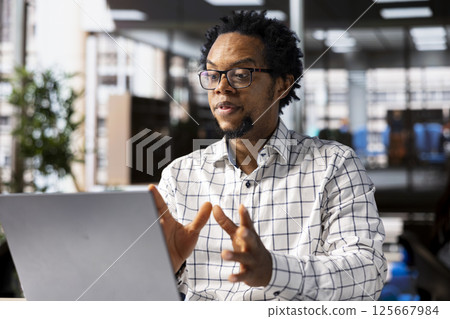 Black man general manager connects with his team via video call, reviewing business operations and strategic objectives. Using online communication to enable efficient decision making. Black man general manager connects with his team via video call, reviewing business operations and strategic objectives. Using online communication to enable efficient decision making. 125667984