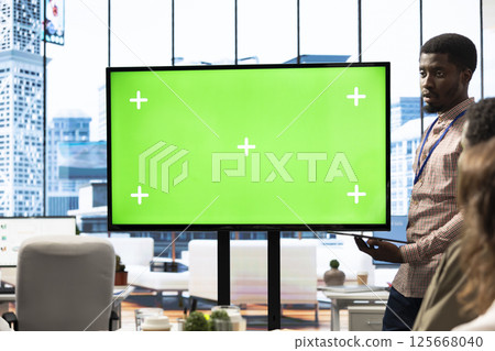 Diverse group of startup employees looking at green screen on an interactive board, meeting to discuss ideas and details to ensure organizational progress. Forecast affiliates in office. Diverse group of startup employees looking at green screen on an interactive board, meeting to discuss ideas and details to ensure organizational progress. Forecast affiliates in office. 125668040