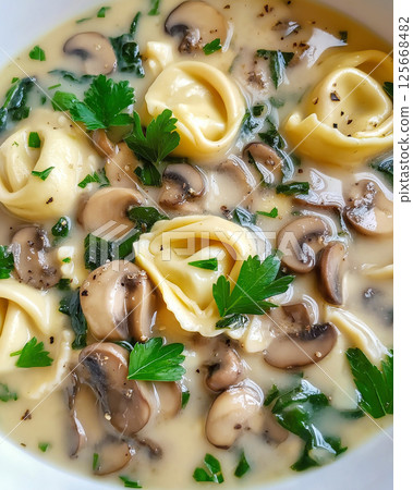 Delicious tortellini mushroom soup with parsley, creamy spinach, and savory broth for dinner 125668482