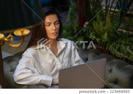 Businesswoman using laptop on cushioned chair in 125668985