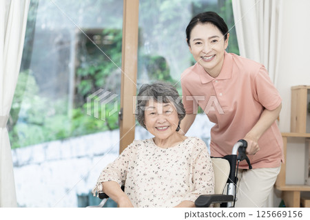 Caregiver caring for a senior woman sitting in a wheelchair 125669156