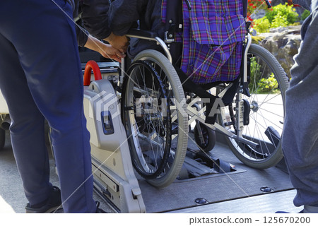A caregiver putting an elderly person in a care taxi A caregiver putting an elderly person in a care taxi 125670200