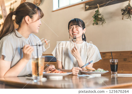 亞洲年輕女性在咖啡館、餐廳吃午飯時聊天 125670264