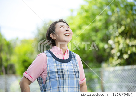 一位資深護理人員或幼兒園老師微笑著抬頭的照片 一位資深護理人員或幼兒園老師微笑著抬頭的照片 125670494